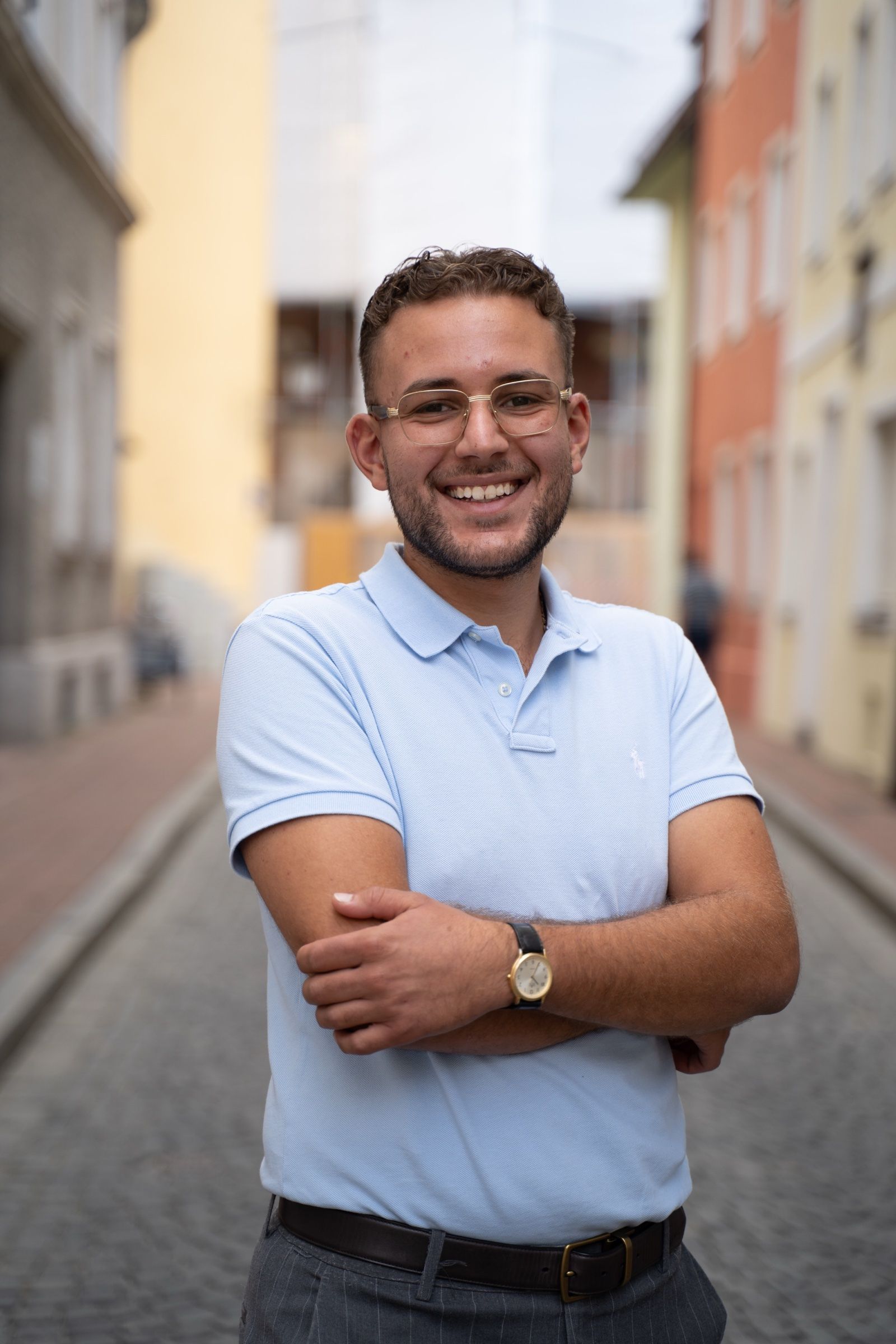 Alexander Kretschmer lächelnd mit verschränkten Armen in einer Altstadtgasse